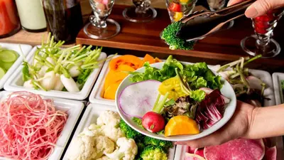 a person holding a bowl of vegetables and fruits at JR East Hotel Mets Premier Gotanda in Tokyo