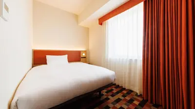 a bedroom with a bed and a large window at JR-East Hotel Mets Koenji in Tokyo