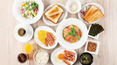 a table with plates of breakfast foods on it at JR-East Hotel Mets Koenji in Tokyo