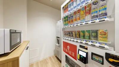 a room with a tv and a shelf of food at JR-East Hotel Mets Koenji in Tokyo
