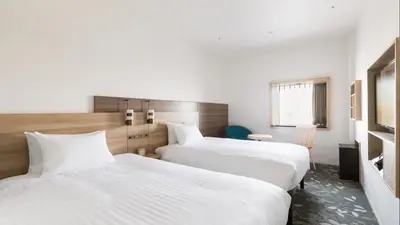 two beds in a hotel room with white sheets at JR East Hotel Mets Premier Tokyo Bay Shinkiba in Tokyo