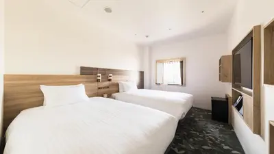 two beds in a hotel room with white sheets at JR East Hotel Mets Premier Tokyo Bay Shinkiba in Tokyo