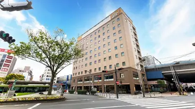 a tall building on a city street with a bus at JR-East Hotel Mets Akabane in Tokyo