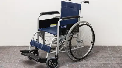 a blue wheelchair sitting against a white wall at JR-East Hotel Mets Omori in Tokyo
