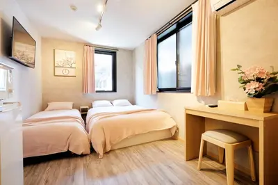 two beds in a room with a desk and two windows at Designed apart ment Yamanote Line Shin-Okubo Sta 3 min walk in Tokyo