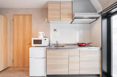 a kitchen with a white refrigerator and a microwave at Designed apart ment Yamanote Line Shin-Okubo Sta 3 min walk in Tokyo