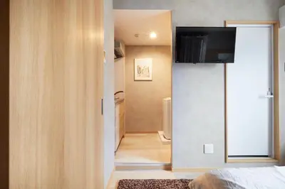 a room with a bed and a television on a wall at Designed apart ment Yamanote Line Shin-Okubo Sta 3 min walk in Tokyo