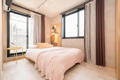 a bedroom with a bed and large windows at Designed apart ment Yamanote Line Shin-Okubo Sta 3 min walk in Tokyo
