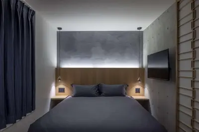 a bedroom with a bed with two nightstands and a window at Spatium Ginza Pony in Tokyo
