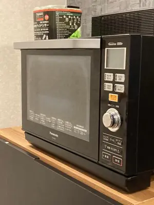 a microwave oven sitting on a shelf on a table at Hostel LodgingToyko Minowa in Tokyo