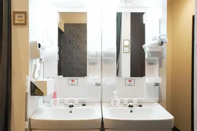 a bathroom with two white sinks and a mirror at Hostel LodgingToyko Minowa in Tokyo