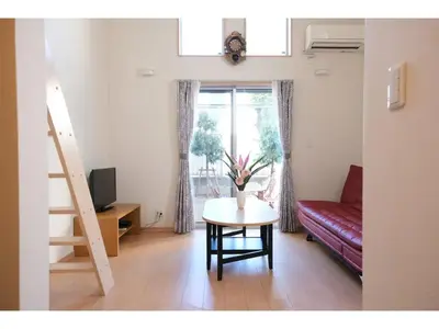 a living room with a table and a red couch at Forest Villa Togoshi - Vacation STAY 44284v in Tokyo