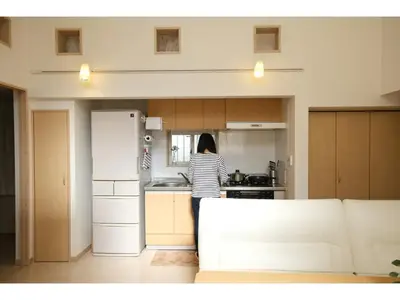 a woman standing in a kitchen with a refrigerator at Forest House - Vacation STAY 44322v in Tokyo