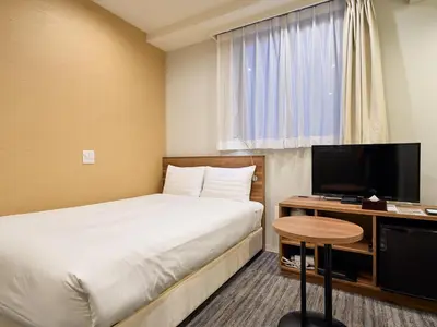 a hotel room with a bed and a television at Tabist Ginza in Tokyo