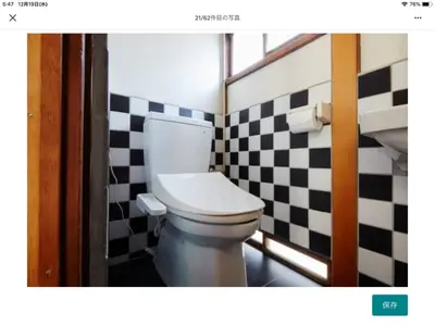 a bathroom with a toilet and a checkered wall at Asahiyuplus in Tokyo