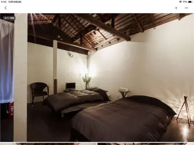 a bedroom with two beds and a chair in it at Asahiyuplus in Tokyo