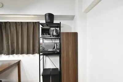 a kitchen with a black shelf with a microwave at LUCKY house43 in Tokyo