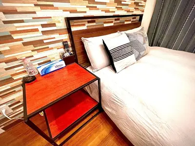 a bedroom with a bed with a nightstand next to a bed sidx sidx sidx at tani house in Tokyo