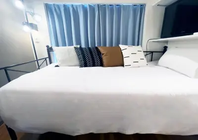 a large white bed in a room with a window at tani house in Tokyo