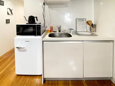 a small kitchen with a sink and a microwave at tani house in Tokyo
