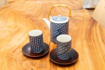 three blue and white cups on a wooden table at \u54c1\u5ddd\u30a6\u30a3\u30b9\u30c6\u30ea\u30a2\u30ec\u30b8\u30c7\u30f3\u30b9 - Shinagawa Wisteria Residence in Tokyo