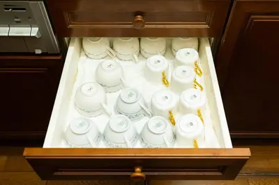 a drawer filled with white cups and saucers at \u54c1\u5ddd\u30a6\u30a3\u30b9\u30c6\u30ea\u30a2\u30ec\u30b8\u30c7\u30f3\u30b9 - Shinagawa Wisteria Residence in Tokyo