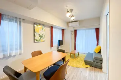a living room with a dining room table and chairs at \u30d1\u30fc\u30af\u30a2\u30af\u30b7\u30b9\u672c\u6240\u543e\u59bb\u6a4b\u30b5\u30a6\u30b9\u30ec\u30b8\u30c7\u30f3\u30b9 in Tokyo