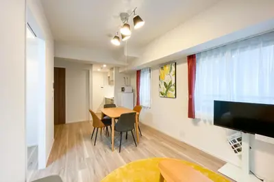 a living room and dining room with a table and chairs at \u30d1\u30fc\u30af\u30a2\u30af\u30b7\u30b9\u672c\u6240\u543e\u59bb\u6a4b\u30b5\u30a6\u30b9\u30ec\u30b8\u30c7\u30f3\u30b9 in Tokyo