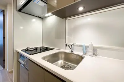 a kitchen with a sink and a stove at \u30d1\u30fc\u30af\u30a2\u30af\u30b7\u30b9\u672c\u6240\u543e\u59bb\u6a4b\u30b5\u30a6\u30b9\u30ec\u30b8\u30c7\u30f3\u30b9 in Tokyo
