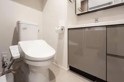 a white bathroom with a toilet and a sink at \u30d1\u30fc\u30af\u30a2\u30af\u30b7\u30b9\u672c\u6240\u543e\u59bb\u6a4b\u30b5\u30a6\u30b9\u30ec\u30b8\u30c7\u30f3\u30b9 in Tokyo