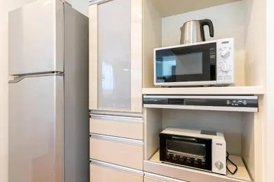a kitchen with a microwave and a refrigerator at SHIBUYA TOKYO in Tokyo