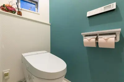 a bathroom with a white toilet and a green wall at SHIBUYA TOKYO in Tokyo