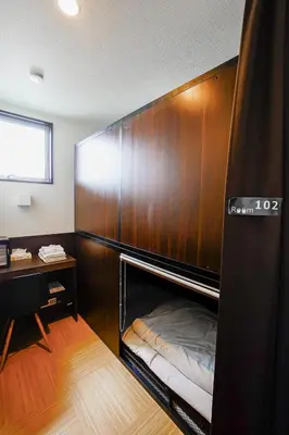 a room with a wooden wall with a bed in it at SAMURAI STAY \u6d17\u8db3\u6c60-male only \u7537\u6027\u5c02\u7528 in Tokyo