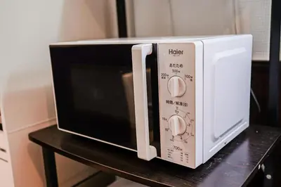 a microwave oven sitting on top of a table at SAMURAI STAY \u6d17\u8db3\u6c60-male only \u7537\u6027\u5c02\u7528 in Tokyo