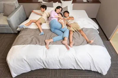 a group of three people laying on a bed at \uff25\uff2e\uff34 \uff34\uff25\uff32\uff32\uff21\uff23\uff25 \uff21\uff33\uff21\uff2b\uff35\uff33\uff21 - Vacation STAY 85533v in Tokyo