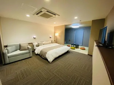 a bedroom with a bed and a couch and a television at \uff25\uff2e\uff34 \uff34\uff25\uff32\uff32\uff21\uff23\uff25 \uff21\uff33\uff21\uff2b\uff35\uff33\uff21 - Vacation STAY 85533v in Tokyo