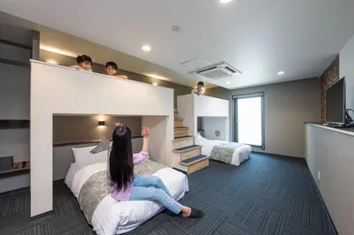 a woman sitting on a bed in a hotel room at \uff25\uff2e\uff34 \uff34\uff25\uff32\uff32\uff21\uff23\uff25 \uff21\uff33\uff21\uff2b\uff35\uff33\uff21 - Vacation STAY 85544v in Tokyo