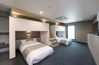 a hotel room with two beds and a staircase at \uff25\uff2e\uff34 \uff34\uff25\uff32\uff32\uff21\uff23\uff25 \uff21\uff33\uff21\uff2b\uff35\uff33\uff21 - Vacation STAY 85544v in Tokyo