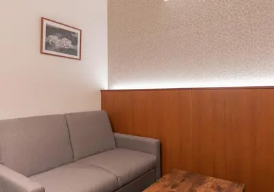 a waiting room with a couch and a table at COCOSHUKU Nakano in Tokyo