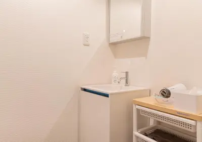 a small white kitchen with a sink and a counter at COCOSHUKU Nakano in Tokyo