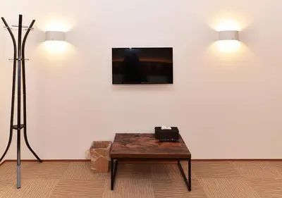 a room with a table and a tv on a wall at COCOSHUKU Nakano in Tokyo