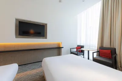 a hotel room with a bed and a tv at JR Kyushu Hotel Blossom Shinjuku in Tokyo