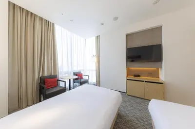 a hotel room with a bed and a flat screen tv at JR Kyushu Hotel Blossom Shinjuku in Tokyo