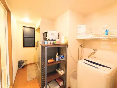 a small kitchen with a refrigerator and a microwave at honeys guest house elevator , wash machine, huge closet space, private bathroom, walk to skytree in 10 minutes in Tokyo