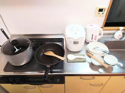 a kitchen counter with pots and pans on a stove at honeys guest house elevator , wash machine, huge closet space, private bathroom, walk to skytree in 10 minutes in Tokyo