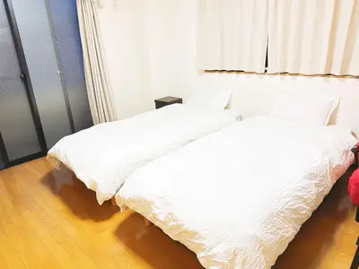 two beds sitting next to each other in a bedroom at honeys guest house elevator , wash machine, huge closet space, private bathroom, walk to skytree in 10 minutes in Tokyo