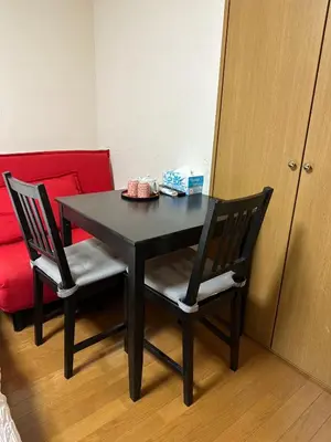 a black table with two chairs and a red couch at honeys guest house elevator , wash machine, huge closet space, private bathroom, walk to skytree in 10 minutes in Tokyo