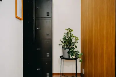 a room with two black lockers and a potted plant at unito light SHIMBASHI in Tokyo