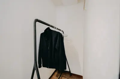 a black jacket hanging on a rack on a wall at unito light SHIMBASHI in Tokyo