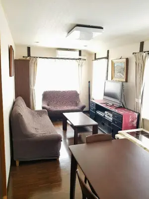 a living room with a couch chair and a television at Homestay Intimo Amigo in Tokyo